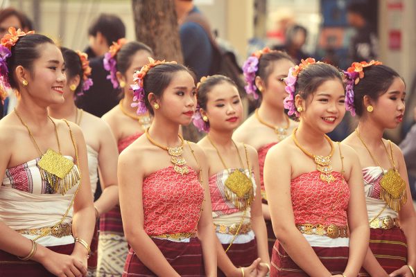 Ragazze in abito tradizionale thai in fila lungo una strada durante una sfilata di festa
